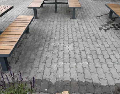 Venkovní posezení u obchodního centra: dlažba zašedlá provozem